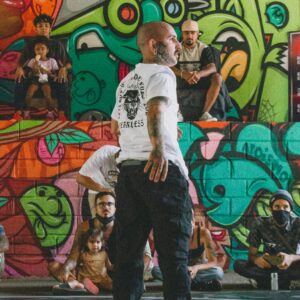 A dynamic street dance performance set against colorful graffiti walls.