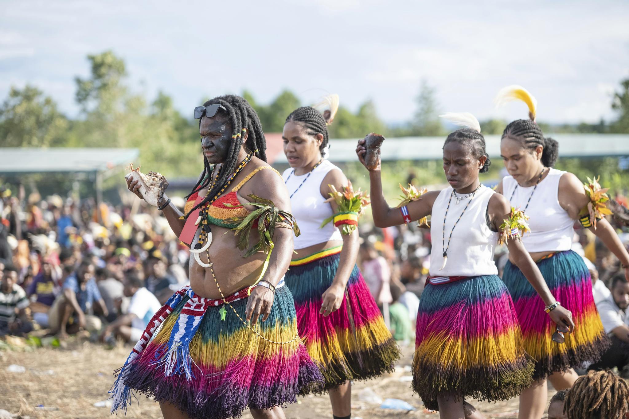 A vibrant display of traditional dance with colorful attire at a cultural festival outdoors.